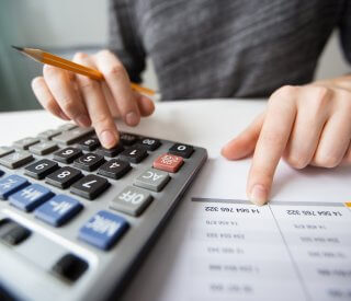 closeup of accountant hands counting on calculator